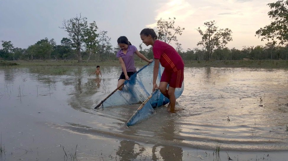 Two Lao girls harvesting aquatic invertebrates
