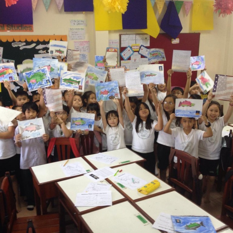 Lao students show letters and salmon drawings they received from California